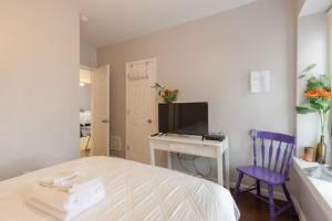 a bedroom with a bed and a desk and a tv at Stay with Jay Cleveland One in Cleveland