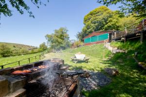 einen Feuergrill in einem Hof mit einem Picknicktisch in der Unterkunft Ty Grug Pods in Bryngwyn