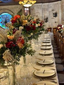 a long table with plates and vases filled with flowers at Dinasty Hotel in Tirana