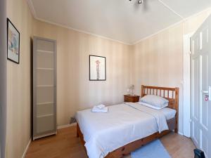 um pequeno quarto com uma cama com lençóis brancos em Långträsk Apartments Villa em Långträsk