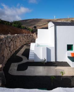 a white house with a stone wall and stairs at Hektor in Teguise