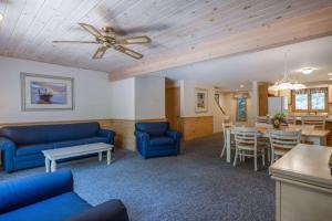un salon avec des canapés bleus et une salle à manger dans l'établissement Southcape Resort Mashpee a Ramada by Wyndham, à Mashpee