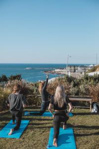 een groep vrouwen die yoga doet op het strand bij You and the sea in Ericeira