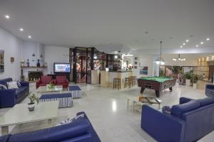 a living room with blue couches and a pool table at Latania Apartments in Stalís