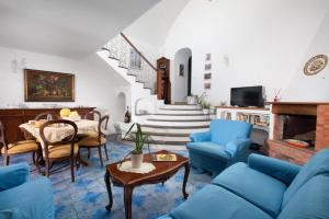 ein Wohnzimmer mit blauen Möbeln und einer Treppe in der Unterkunft Estate4home- La casa del Maresciallo in Positano