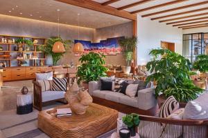 a living room filled with furniture and potted plants at Mission Pacific Beach Resort, part of JdV by Hyatt in Oceanside