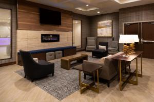 a lobby with a waiting area with chairs and a tv at Residence Inn by Marriott Charlotte Northlake in Charlotte