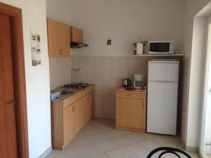a small kitchen with a sink and a refrigerator at Apartment and Studio Jelušić in Pinezici