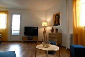 uma sala de estar com uma televisão e uma mesa em Grand appartement cosy-Hyper Centre-Place Verdun em Tarbes