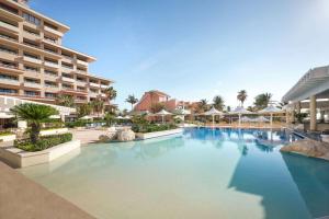- une piscine dans un complexe avec un grand bâtiment dans l'établissement Wyndham Grand Cancun All Inclusive Resort & Villas, à Cancún