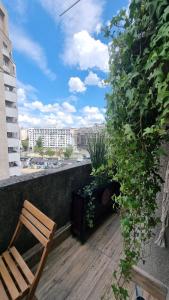 a wooden chair sitting on a balcony with a plant at Vânători Nest - 2 room - Pumo properties in Bucharest