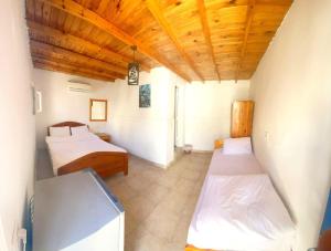 a bedroom with two beds and a wooden ceiling at Auski Hostel Dahab in Dahab