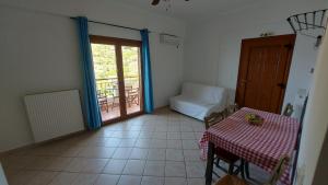 a dining room with a table and a room with a balcony at Anarrousa Studios & Apartments in Evdilos