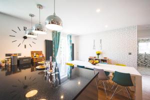 a kitchen with a table and a clock on the wall at Luxury 4 Bed, 3 Bathroom, Pet Friendly Villa, Sleeps 8, with Hot Tub in Trearddur Bay in Trearddur