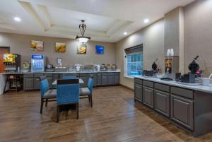 un salón con mesa y sillas en una habitación en Baymont Inn & Suites by Wyndham Glen Rose, en Glen Rose