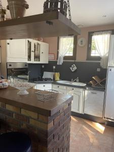 a kitchen with white cabinets and a counter top at Maison Du Lac in Marcillac-la-Croisille