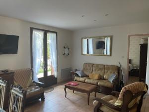 uma sala de estar com um sofá e uma mesa em Maison Du Lac em Marcillac-la-Croisille