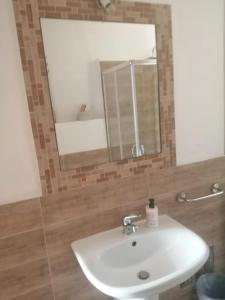 bagno con lavandino bianco e specchio di Elia's House a Padru
