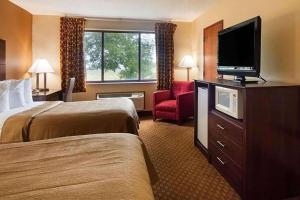 ein Hotelzimmer mit 2 Betten und einem Flachbild-TV in der Unterkunft Super 8 by Wyndham Sturtevant Racine in Sturtevant