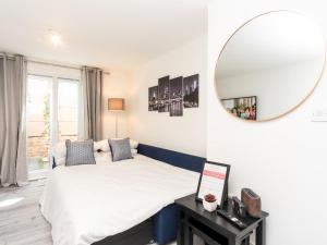 a bedroom with a bed with a mirror on the wall at Pass the Keys Fresh and Stylish Central Flat With Parking and Garden in London