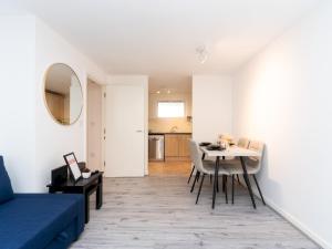 uma sala de estar com um sofá azul e uma mesa em Pass the Keys Fresh and Stylish Central Flat With Parking and Garden em Londres