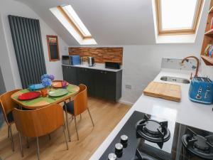 eine Küche mit Tisch und eine Küche mit Herd in der Unterkunft The Loft Wisteria Cottage in Saundersfoot + 13 Fotos