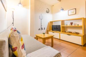 a living room with a couch and a television at Macarena Muralla Encantada in Seville