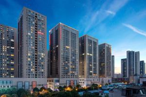 a group of tall buildings in a city at night at Ramada Encore by Wyndham Kunming Guandu in Kunming