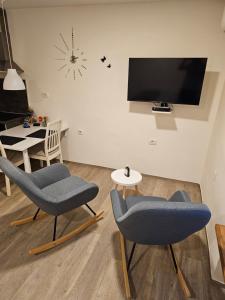 马里博尔Studio Apartma V8的有两把椅子和一台电视的客厅
