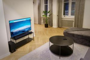 a living room with a television and a coffee table at Stylish apartment in the heart of Tallinn, free parking in Tallinn