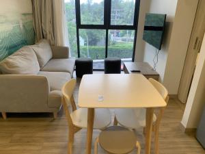 salon ze stołem, krzesłami i kanapą w obiekcie Apartments in Skypark Laguna Bang Tao w mieście Bang Tao Beach