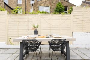 a white table with two chairs on a patio at Tintern Apartment - Clapham in London
