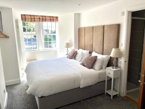 a bedroom with a large bed and two windows at Altonhill House - room only in Nairn