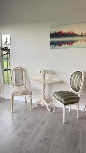 una habitación con 2 sillas, una mesa y una pintura en Riverside en Raheelan
