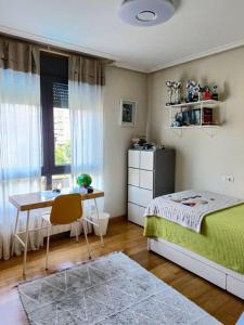 1 dormitorio con cama, escritorio y mesa en Casa en la ciudad. en Ourense