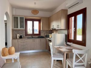 Sea breeze houses في مونوليثوس: مطبخ مع طاولة وثلاجة