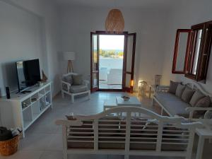 a living room with a couch and a tv at Sea breeze houses in Monolithos