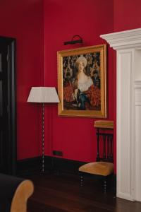 a red wall with a painting of a woman with aelope at L'oscar London in London