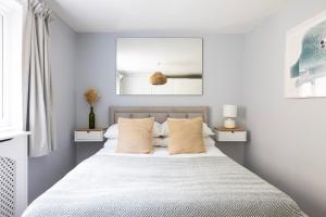 a bedroom with a bed with white sheets and pillows at Tintern Apartment - Clapham in London +27 photos