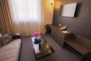 a hotel room with a couch and a table with flowers on it at Cascade Hotel in Yerevan