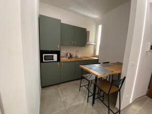 ローマにあるLaura Apartmentのキッチン(緑のキャビネット、木製テーブル付)