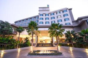 a hotel with a fountain in front of a building at The Grand Riverside Hotel in Phitsanulok