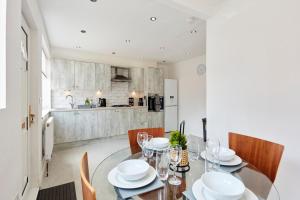a dining room with a table and chairs and a kitchen at Spacious home close to city centre location in Leeds