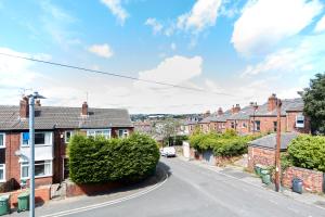 an empty street in a residential neighborhood with brick houses at Spacious home close to city centre location in Leeds