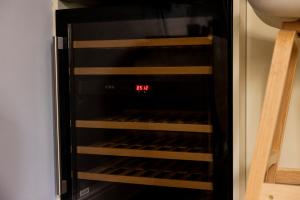 a microwave oven with its door open with a clock at Tintern Apartment - Clapham in London