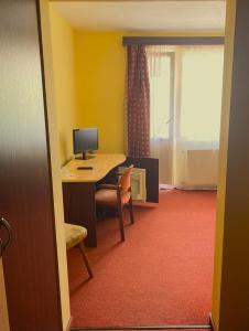Una habitación con un escritorio con una computadora encima. en Pensiunea Iris, en Băile Tuşnad