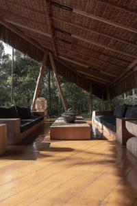 een groot paviljoen met banken op een houten vloer bij KA BRU Forest Villa in Itacaré