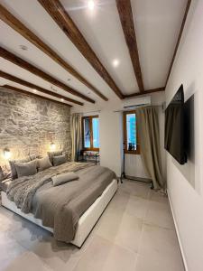 a bedroom with a large bed and a stone wall at Vintage Apartment Rovinj Old Town in Rovinj