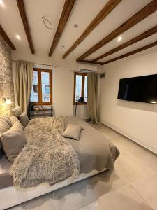 a bedroom with a large bed and a flat screen tv at Vintage Apartment Rovinj Old Town in Rovinj