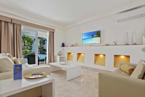 a living room with white furniture and a fireplace at Privè Royal Villa Bahiazul in Corralejo